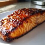 Close-up of a perfectly cooked baked salmon recipe fillet with a shiny, dark brown glaze.