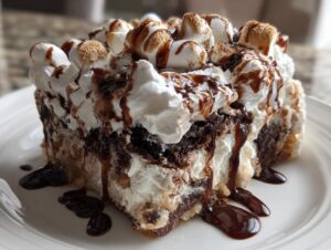 A rich slice of hot chocolate poke cake topped with whipped cream, toasted marshmallows, and chocolate syrup.