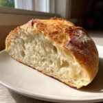 Cross-section view showing the airy, open crumb structure of a freshly baked Italian bread loaf.