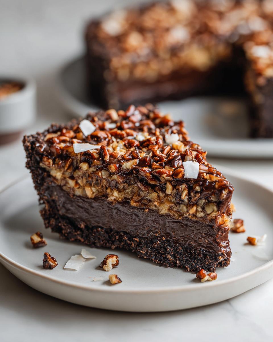 A decadent slice of german chocolate pie featuring a dark chocolate filling and a thick pecan-coconut topping.