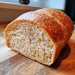 Close-up of a freshly baked loaf of soft whole wheat bread, showing the airy crumb structure.