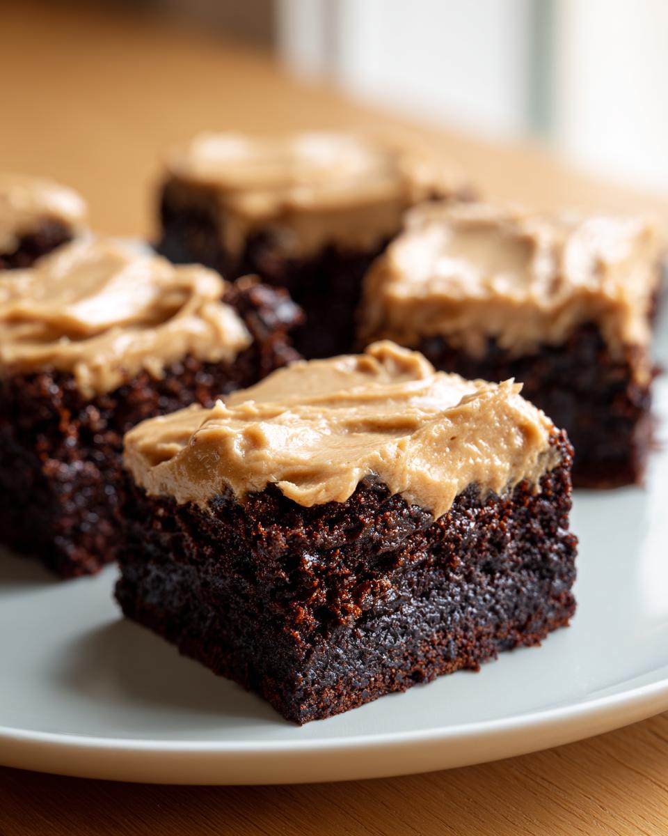 Close-up of a rich, dark chocolate banana bread brownies square topped with creamy peanut butter frosting.