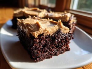 Close-up of a rich, dark chocolate banana bread brownies square topped with thick peanut butter frosting.