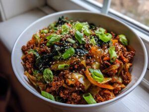 A close-up view of a hearty serving of egg roll in a bowl, topped with sesame seeds and fresh green onions.