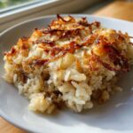 A close-up serving of creamy French onion butter rice topped with melted cheese and crispy caramelized onions.