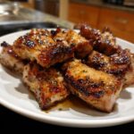Close-up of perfectly cooked, glazed chicken pieces showing char and herbs, result of the amazing chicken marinade.