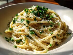 A close-up of creamy parmesan pasta tossed with grated cheese and topped generously with chopped fresh parsley.
