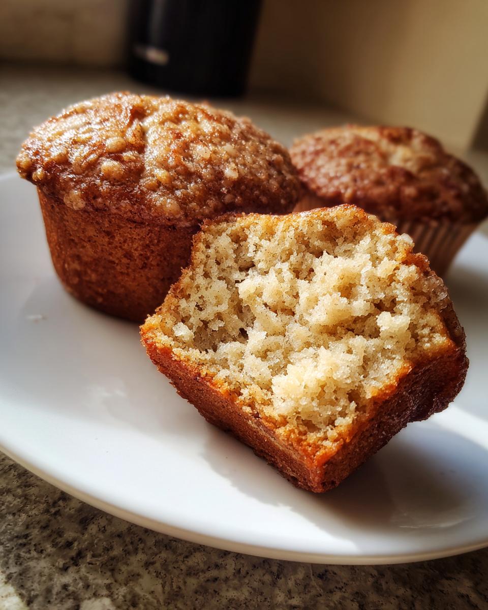 Close-up of a sourdough discard banana muffin cut in half showing the moist crumb texture.