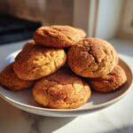 A warm stack of freshly baked pumpkin snickerdoodle cookies coated in cinnamon sugar.