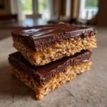 Two stacked bars of graham cracker toffee featuring a crunchy base, gooey caramel, and a thick chocolate topping.